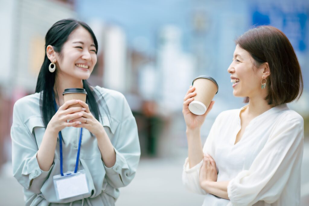 コーヒー片手に笑い合う女性社員たち